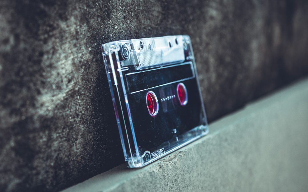 A cassette tape leans against a dark stone wall